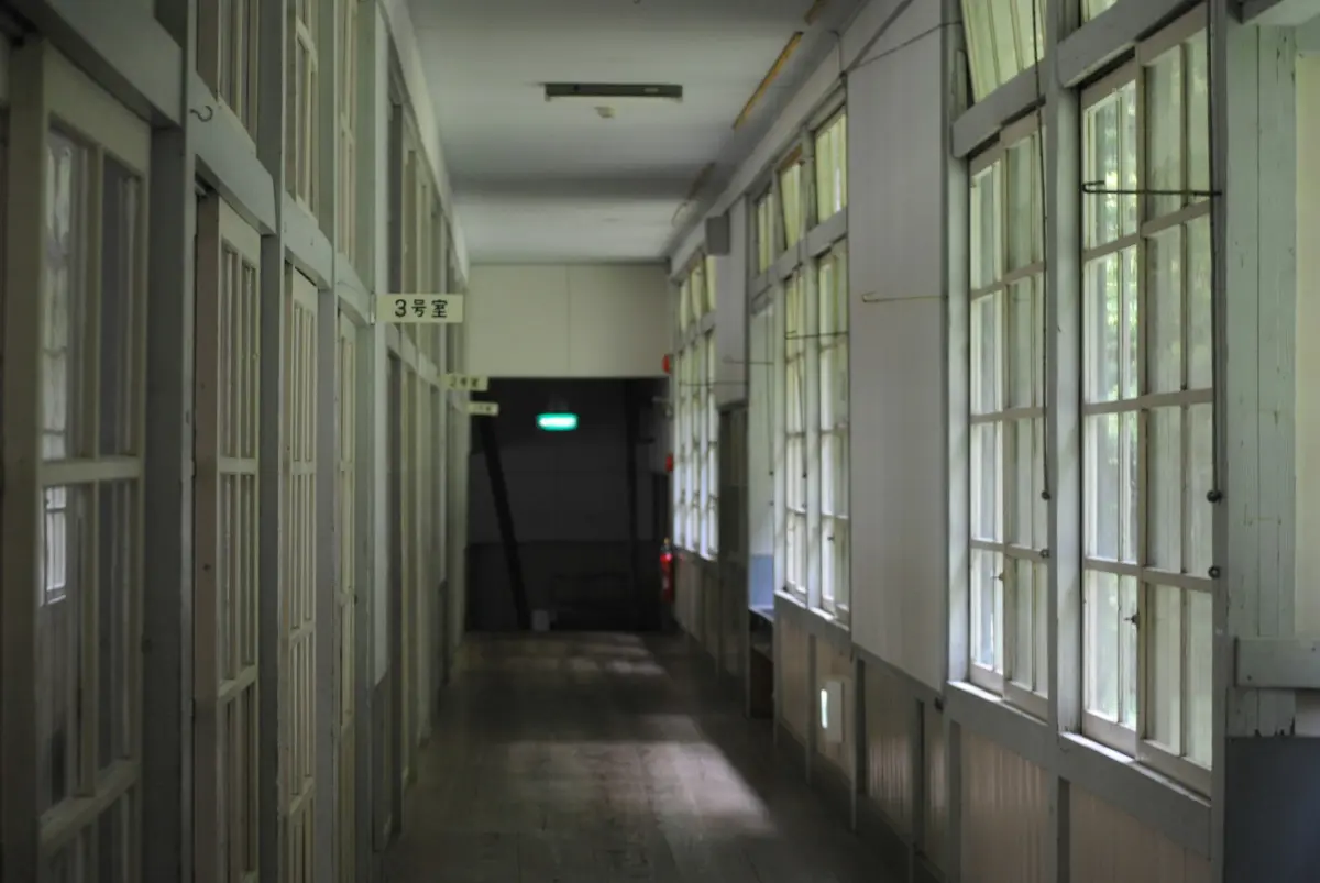 a long hallway with several windows and a green light