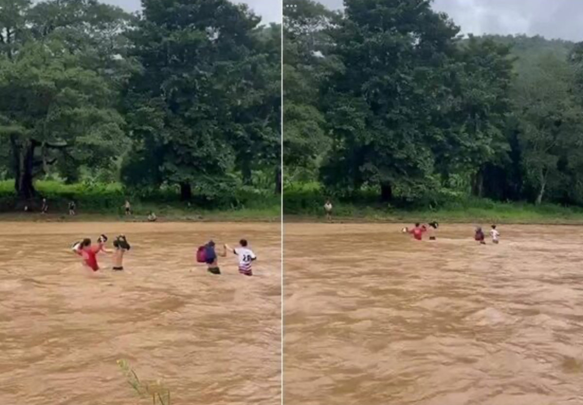Schulkinder waten durch reißenden Fluss
