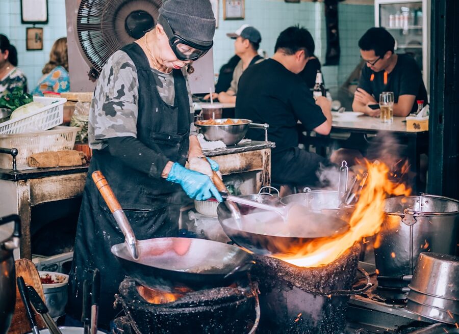 a man cooking food in a kitchen on top of a stove